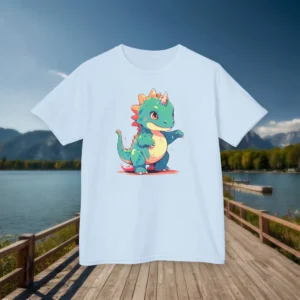 Front view of a sky blue kids t-shirt featuring a colorful cartoon baby Iguanodon with a unicorn horn, displayed on a boardwalk by a mountain lake.