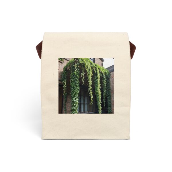 Canvas lunch bag with strap featuring a cascading greenery over a brick wall design