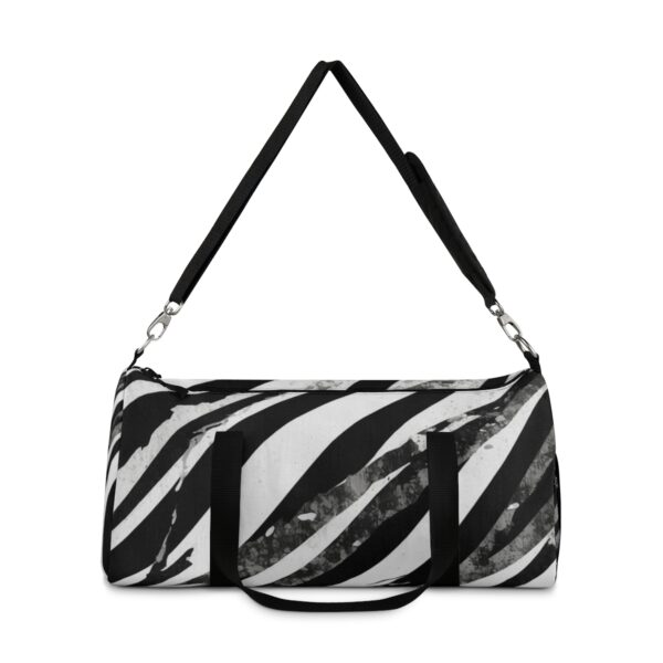 Duffel bag with bold diagonal black and white stripes and adjustable shoulder strap