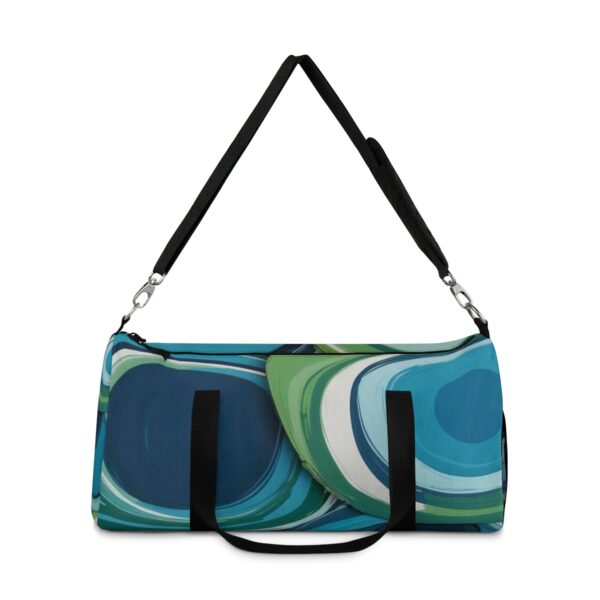 Duffel bag with large, flowing overlapping circular patterns and adjustable shoulder strap