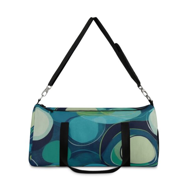 Duffel bag with bold overlapping circular patterns and adjustable shoulder strap