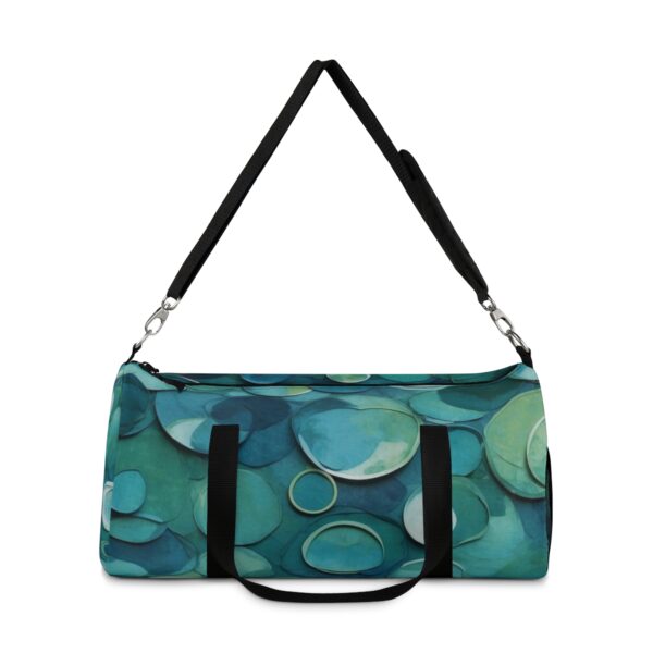 Duffel bag with layered overlapping circular patterns and adjustable shoulder strap