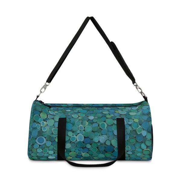 Duffel bag with small overlapping circular patterns and adjustable shoulder strap