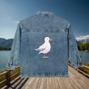 Flat view of a denim jacket featuring a seagull illustration on the back.