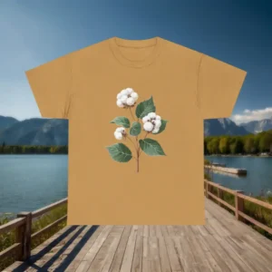 Mustard t-shirt with a cotton plant design laid flat on a wooden dock