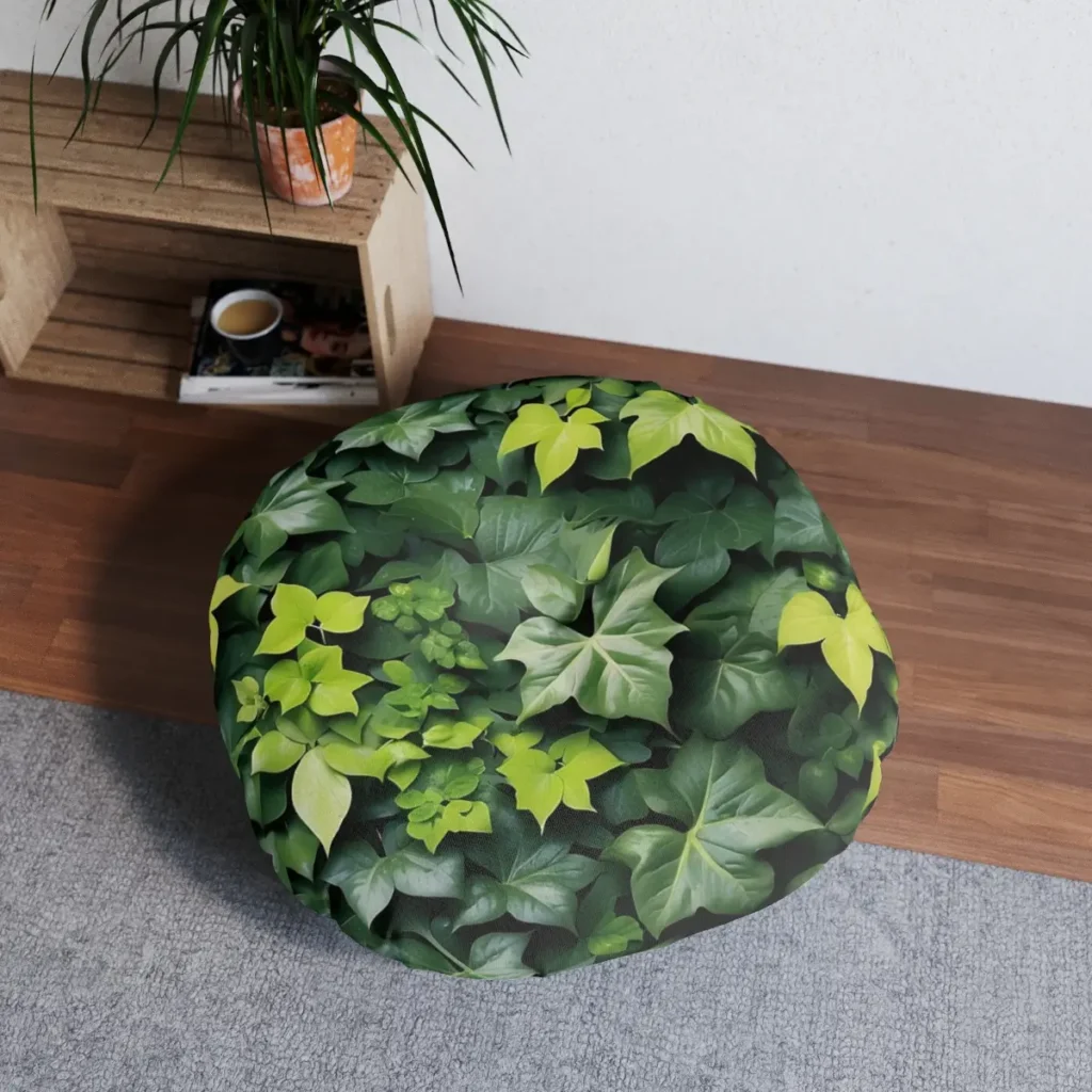 round tufted floor pillow with a climbing ivy design featuring lush green leaves placed on a wooden floor