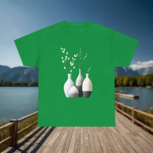 Green t-shirt with a printed design of modern decorative vases and plants displayed on a wooden dock in front of a lake