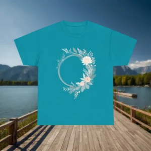 Flat lay of teal t-shirt featuring a circular floral wreath with soft pink and white flowers