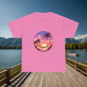 Pink t-shirt with a graphic of a tropical sunset, palm trees, and hammock displayed on a wooden dock with lake and mountain backdrop